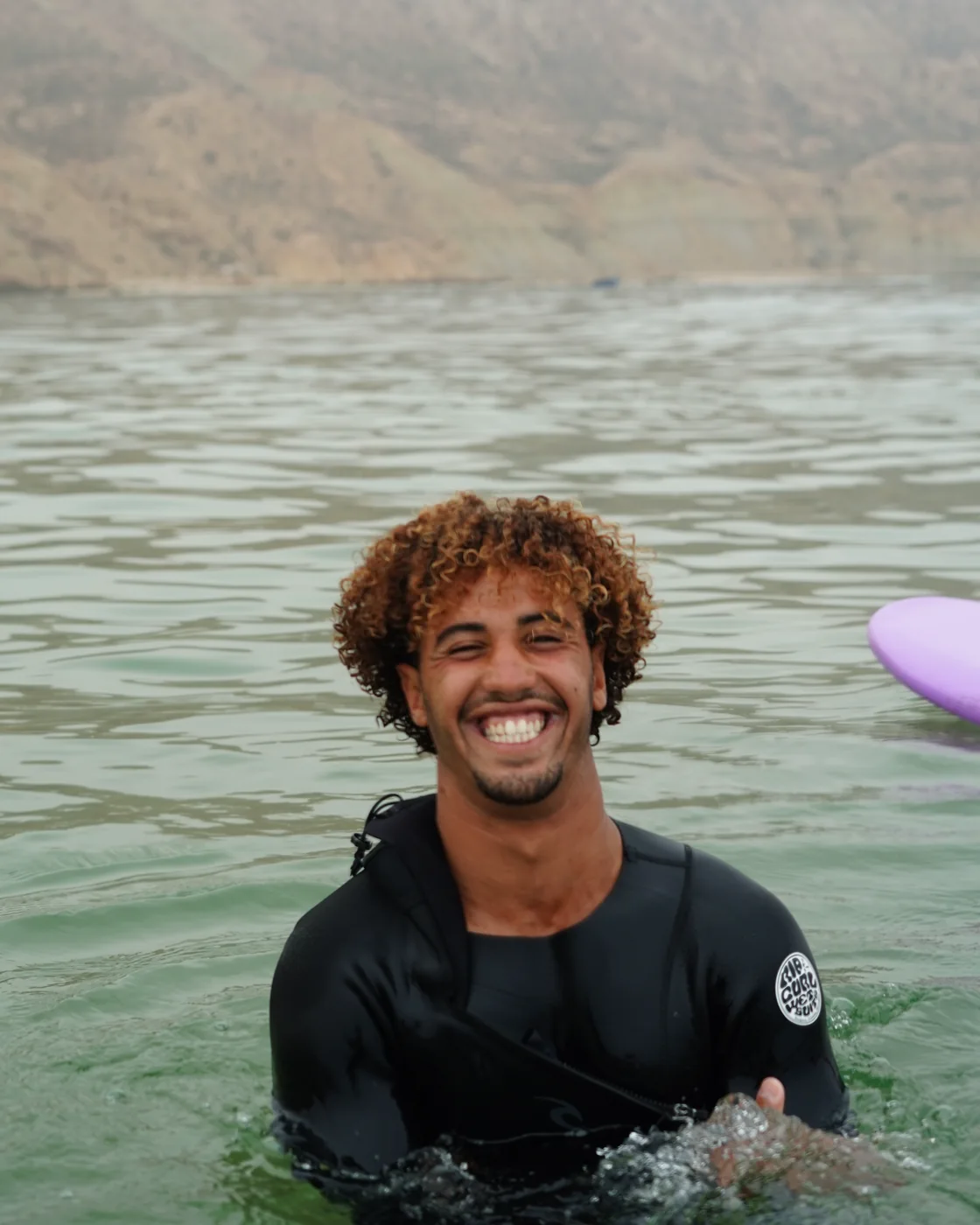 Amine Soussi, coach de surf, souriant dans l’eau