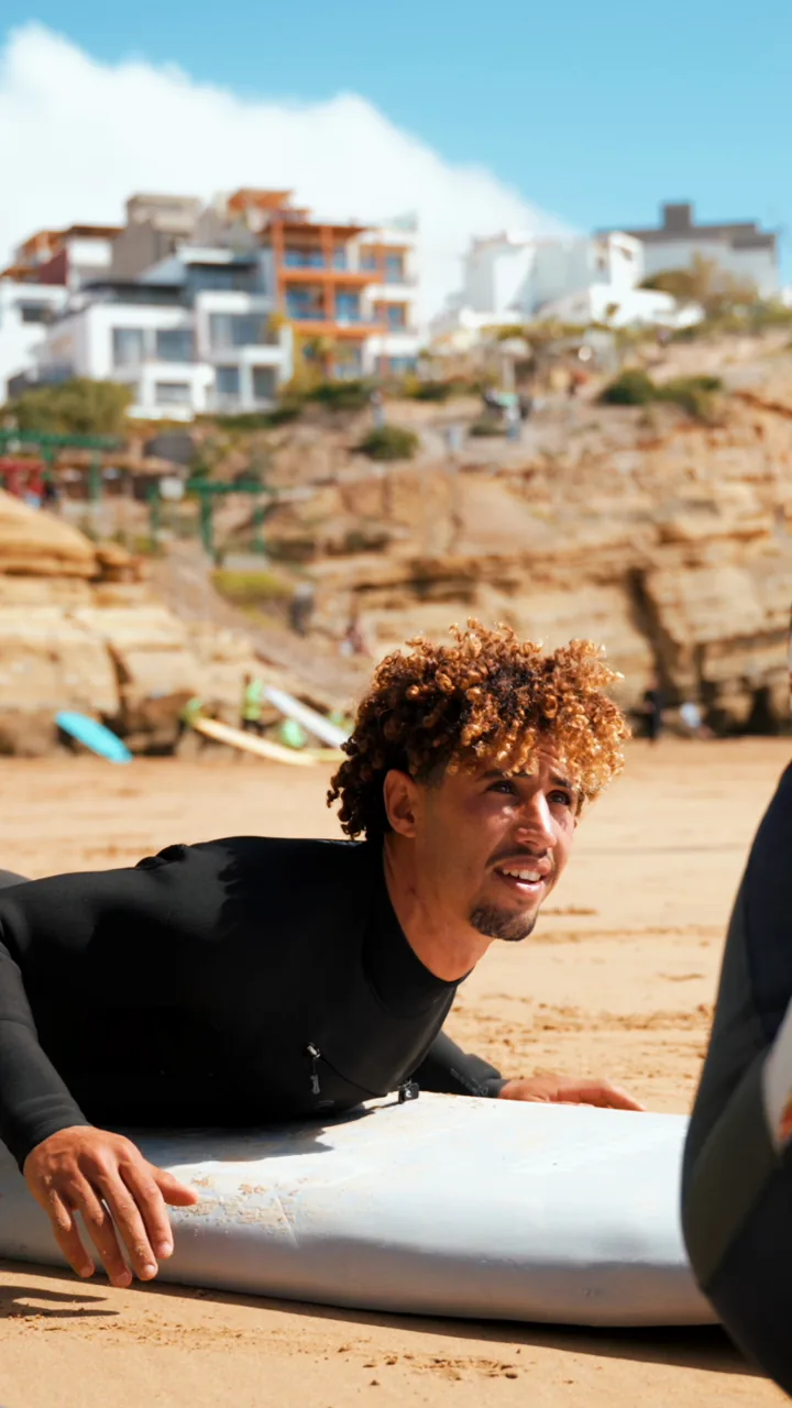 Amine montre la position de rame sur une planche pendant un cours de surf